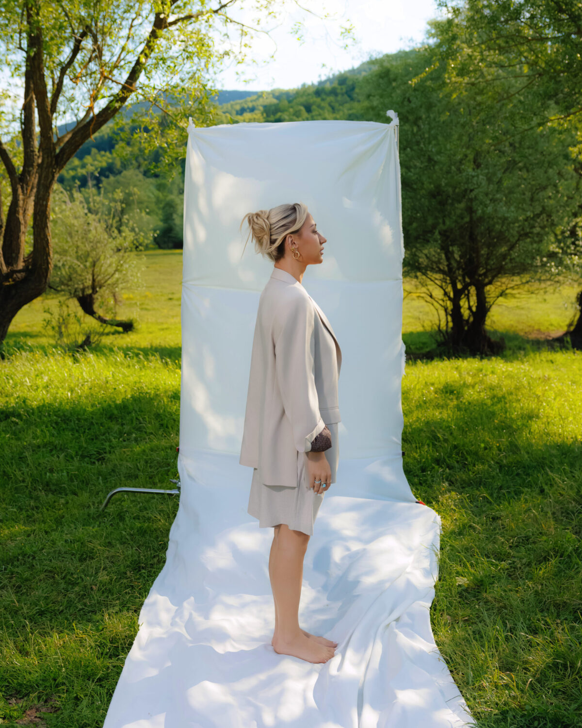 Model in a cream linen set standing in a meadow